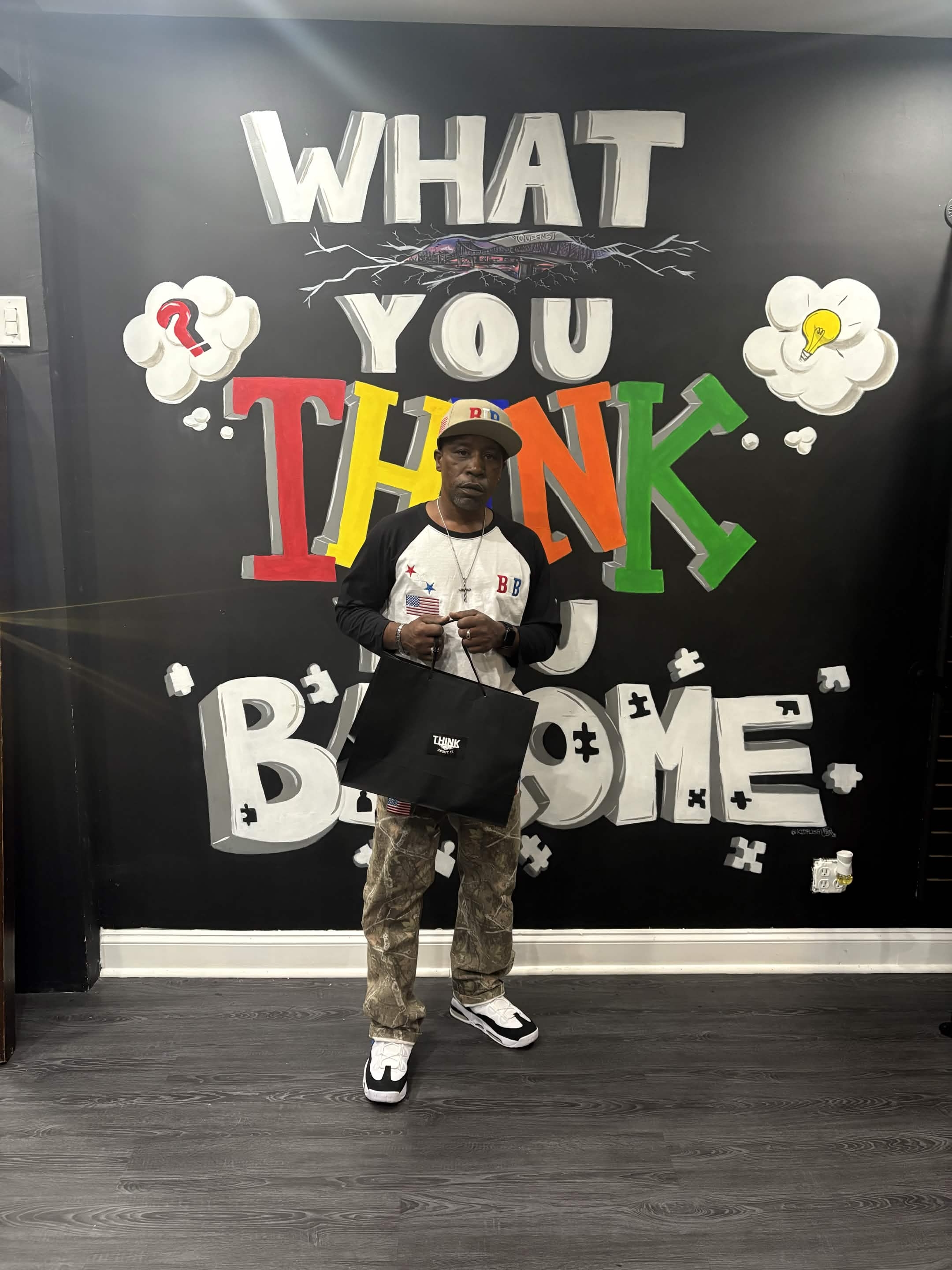 Lernard in front of the What You Think You Become mural