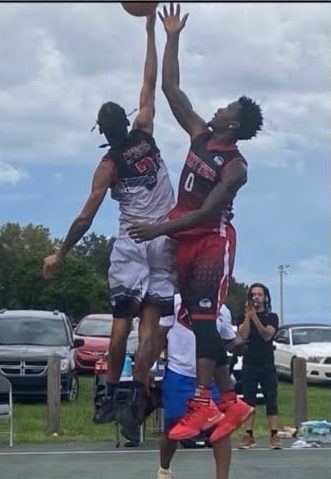 Two players going up for a contested block at the rim
